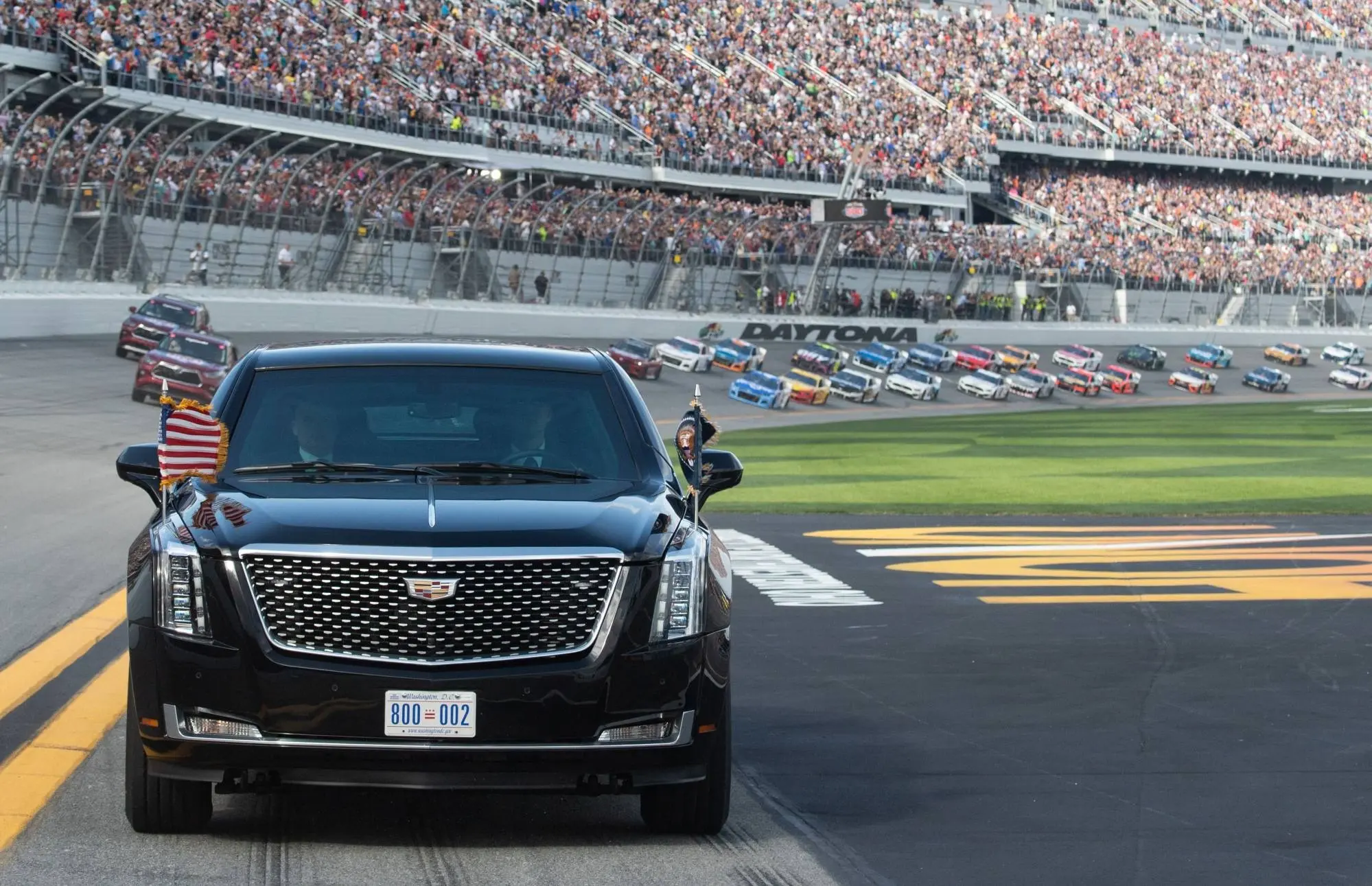 Xe limousine Cadillac màu đen trên đường đua đông khán giả