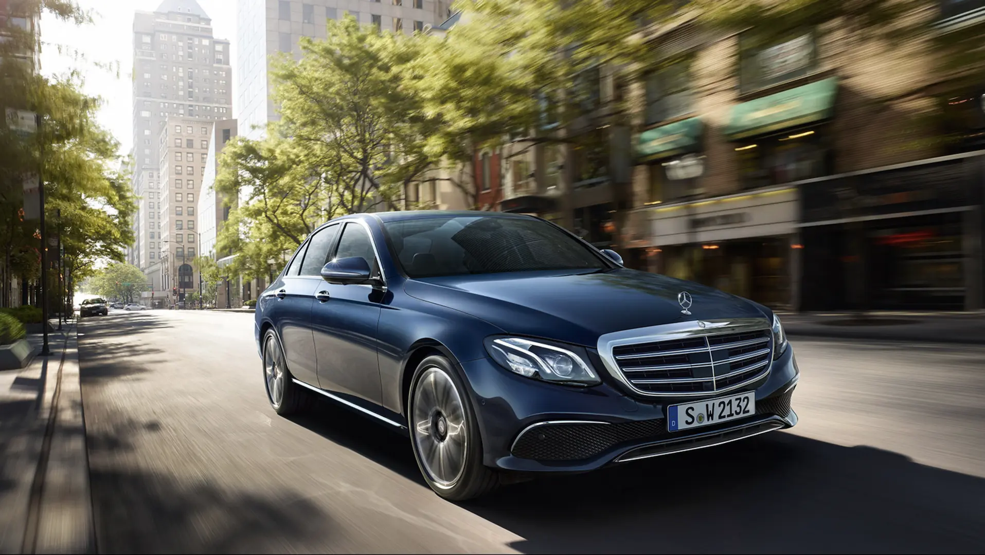 Xe Mercedes-Benz sedan màu xanh đậm chạy trên phố