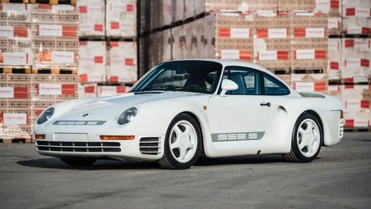 Xe Porsche 959 màu trắng đỗ trước kho hàng