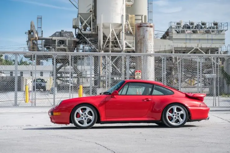 Xe Porsche 993 màu đỏ đỗ trước nhà máy