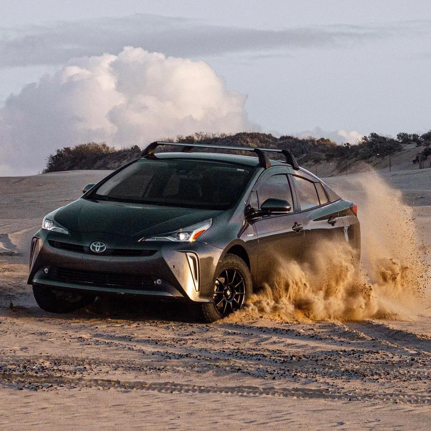 Xe Toyota Prius màu xám chạy trên cát